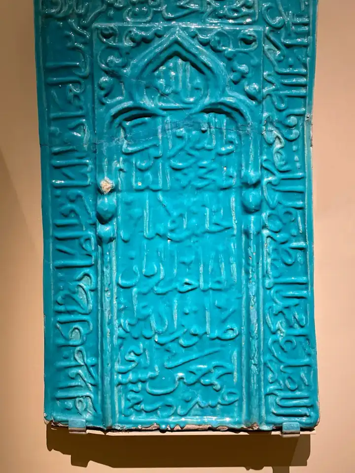 Niş desenli tek çini; kemer formunun içinde ince bitkisel dolgu.